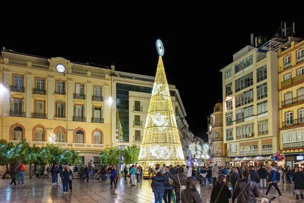 stock image Malaga, Spain - November 25, 2023: Christmas tree in Plaza de la Constitucion, Constitution Square of Malaga City, with people enjoying decoration, in Malaga. People might be blurred by movement