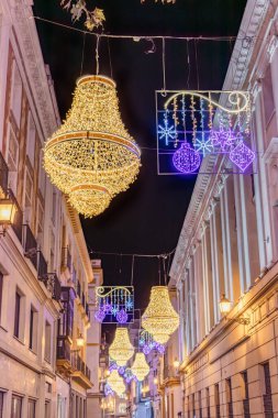 İspanya 'nın başkenti Endülüs' ün merkezinde, Sierpes caddesindeki Noel ışıkları süslemesi altın imparatorluk tarzı bir kristal şamdan şeklinde. En yakın ışık çizgisinde seçici odak