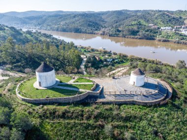 Huelva 'nın Endülüs bölgesindeki Sanlucar de Guadiana köyündeki eski beyaz yel değirmenlerinin, Guadiana nehrinin kıyısındaki Portekiz sınırındaki hava aracı görüntüsü.