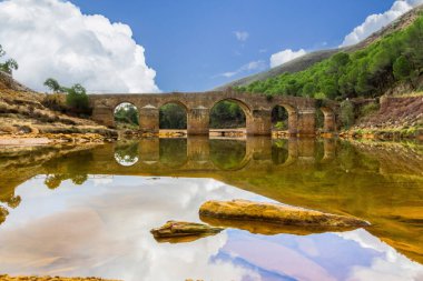 İspanya 'nın Endülüs eyaletindeki Sotiel Coronada eyaletinden Odiel nehri boyunca uzanan su değirmenlerinin yürüyüş rotasında Roma köprüsü.