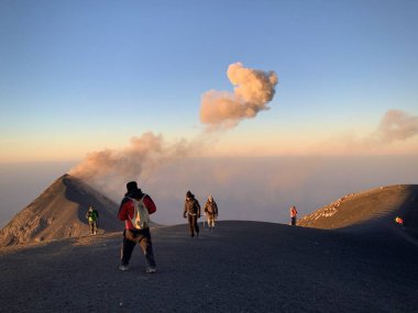 Antigua, Sacatepequez, Guatemala... 18 Şubat 2020: Gündoğumunda volkan üzerinde beş yürüyüşçü 