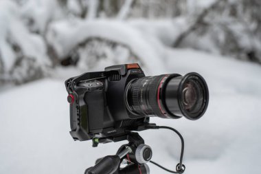 Tallinn, Estonya - Şubat 03 2022: Blackmagic Design Pocket Cinema Camera 6K Pro with Smallrig cage, and Samsung T5 SSD kullanıma hazır. Kışın açık havada kamera kullanmak. Seçici odak.