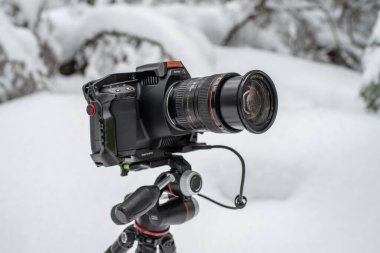 Tallinn, Estonya - Şubat 03 2022: Blackmagic Design Pocket Cinema Camera 6K Pro with Smallrig cage, and Samsung T5 SSD kullanıma hazır. Kışın açık havada kamera kullanmak. Seçici odak.
