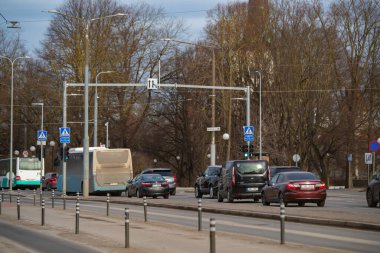 Tallinn, Estonya - 9 Mart 2025: Tallinn şehir merkezindeki işlek sokak sahnesi (Estonya - Kesklinn), Toompuiestee caddesi. Açık bir bahar gününde trafik ışıklarında arabalar ve otobüsler.