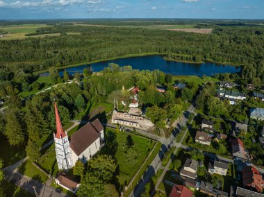 Tri, Estonya - 24 Ağustos 2024: Güneşli bir günde yukarıdan bir kasabanın manzarası. Soldaki Turi St. Martins Kilisesi (Tri Pha Martini kirik). Arka planda göl ve ormanlık alanlar görülebilir..