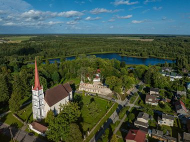 Tri, Estonya - 24 Ağustos 2024: Güneşli bir günde yukarıdan bir kasabanın manzarası. Soldaki Turi St. Martins Kilisesi (Tri Pha Martini kirik). Arka planda göl ve ormanlık alanlar görülebilir..