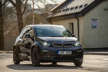 Tallinn, Estonia - March 23 2025: Stylish dark blue BMW i3s 2021 electric car parked in front of an old building. Eco-friendly, automotive and city lifestyle concept.