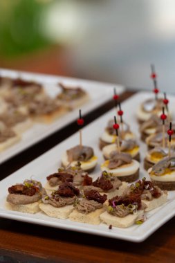 Çavdar ekmeğine yumurta ve ançüezli gurme kanepeleri. Lezzetli aperatifler, dekolte ısırıklar ve güneşte kurutulmuş domatesler içeren zarif yemek organizasyonu. Seçici odak.