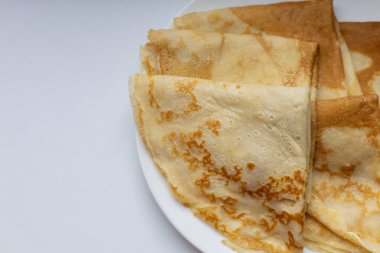 Geleneksel Rus ve Estonya krepleri (blini) beyaz bir tabakta katlandı. Stok fotoğrafçılığı için mükemmel. Ev yapımı yemekler, Doğu Avrupa mutfağı, kahvaltı kavramları ya da minimalist yemekler üzerine odaklı..