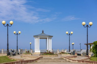 Sillamae, Estonya 'daki yeni gezinti alanında güneşli bir yaz gününde Baltık Denizi' ne bakan zarif beyaz bir pavyon. Seyahat, turizm, mimarlık, yaz tatili, kıyı yaşam tarzı konsepti.