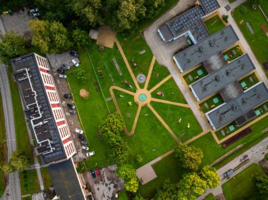 Vinni, Estonya - 10 Ağustos 2025: Renkli anaokulu ve çocuk bahçesi. Radikal kum yolları, yeşil çimenler, ağaçlar ve yerleşim yerleriyle çevrili merkezi bir oyun alanına götürür..