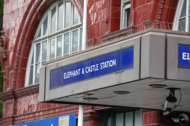 Londra 'daki Elephant ve Castle İstasyonu tabelasının yakın çekimi. Simgesel kırmızı tuğla ve tabela görünür.