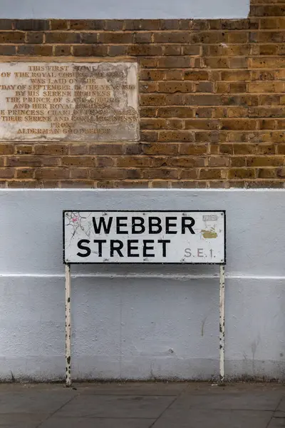 Webber Caddesi 'ndeki tabelayı Londra' daki tuğla bir duvara yakın çekim. Yukarıda tarihi plaketler var.
