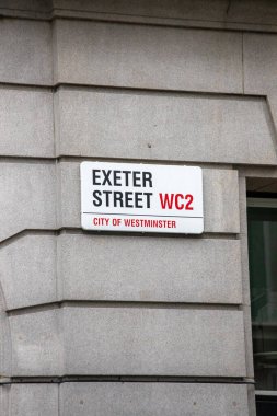 Londra 'nın Westminster şehrindeki Exeter Caddesi' nin sokak tabelası. Modern bir taş duvara yerleştirilmiş..