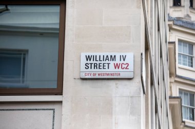 Westminster, Londra 'daki IV. William Caddesi tabelasına yakın çekim. Şehir mimarisi görünür.