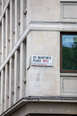 Westminster, Londra 'daki St. Martin' s Place sokak tabelasının yakınında. Taş bina cephesinde klasik kırmızı ve beyaz tasarım..