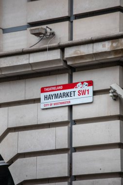 Londra 'nın Westminster şehrindeki Haymarket için sokak tabelası. Görüntü, şehir mimarisini ve bir güvenlik kamerasını yakalıyor..