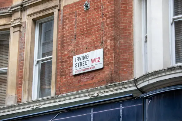 Londra, Westminster 'da kırmızı tuğlalı bir binanın üzerindeki Irving Sokağı tabelasına yakın çekim..
