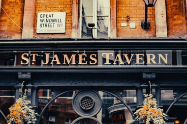 Londra 'daki Great Windmill Caddesi' ndeki St. James Tavern tabelasının manzarasında klasik mimari öğeler ve sokak tabelasıyla.