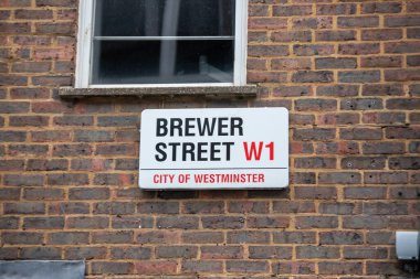 Westminster, Londra 'daki Brewer Sokağı' nın sokak tabelası. Tabela bir pencerenin altındaki tuğladan duvara asılmış..