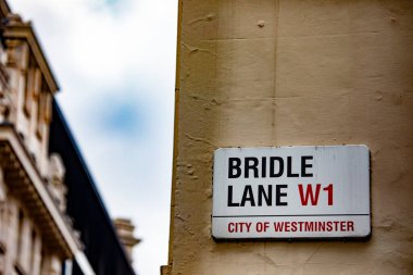 Westminster, Londra 'daki Bridle Lane sokak tabelasına yakın çekim. Şehir mimarisini ve ikonik şehir işaretini yakalar.