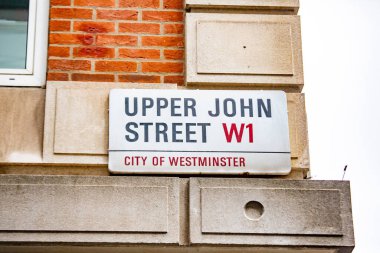 Westminster, Londra 'daki Yukarı John Caddesi' nin sokak tabelası. Tabela tuğla ve taş bir duvara asılmış..