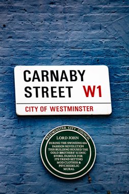 Westminster, Londra 'daki Carnaby Caddesi' nin tabelaları mavi tuğlalı bir duvarda..