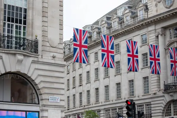 Tarihi mimariye karşı Piccadilly Circus, Londra 'da sendika bayrakları sergileniyor.