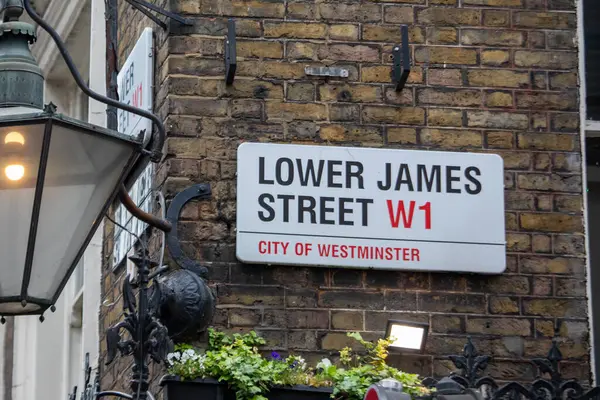 Westminster, Londra 'daki Lower James Caddesi' nin sokak tabelası. Tuğla duvar ve klasik lamba direği.