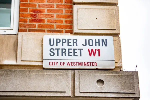 Westminster, Londra 'daki Yukarı John Caddesi' nin sokak tabelası. Tabela tuğla ve taş bir duvara asılmış..