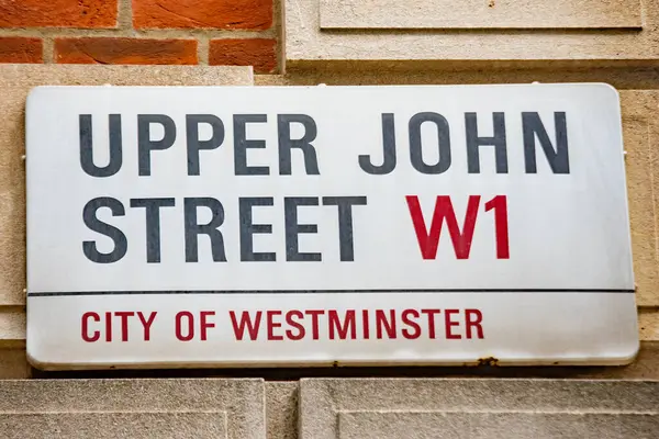 Westminster, Londra 'daki Yukarı John Caddesi için sokak tabelası. İşaret, merkezi konumunu gösteren W1 posta kodunu içeriyor.