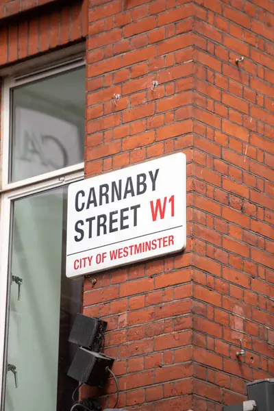 Londra, İngiltere 'deki kırmızı tuğlalı duvarda Carnaby Sokağı tabelası var..