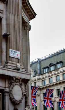 Londra Oxford Caddesinde klasik mimari, Union Jack bayraklarıyla. İkonik alışveriş bölgesi sahnesi.