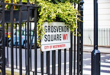 Westminster, Londra 'daki Grosvenor Meydanı' nın sokak tabelası. Görüntü yeşillik içeren klasik bir şehir ortamını gösteriyor.