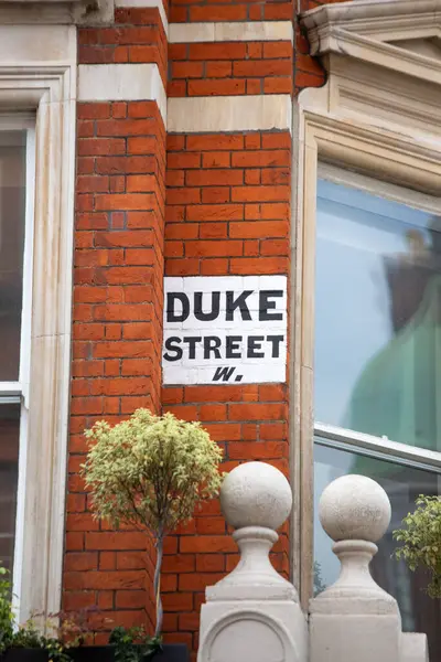 Londra 'da kırmızı tuğlalı bir duvarda Duke Caddesi için bir tabela asılıydı. Tabela beyaz arkaplanda koyu siyah harfler içeriyor..