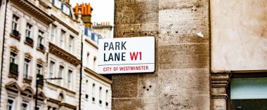 Westminster, Londra 'daki Park Lane' in sokak tabelası. Arkaplandaki tarihi binalar.