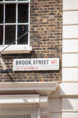 Westminster, Londra 'daki Brook Street W1 için sokak tabelası. Tabela tuğla bir duvara asılmış..