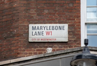 Westminster 'daki Marylebone Yolu' nun sokak tabelası. Tuğla bina ve kısmi pencere görünür.