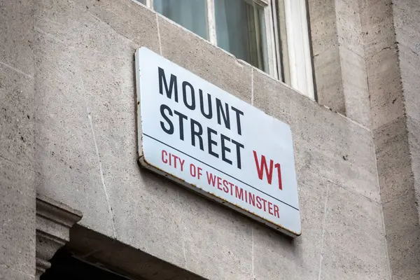 Westminster, Londra 'daki Mount Street için bir sokak tabelası. Tabela taştan bir duvarda ikonik W1 posta kodunu gösteriyor.