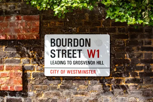 Londra 'nın Westminster şehrindeki Bourdon Sokağı' nın sokak tabelası. Tuğla duvar ve yeşillik şehir sahnesine ekleniyor.
