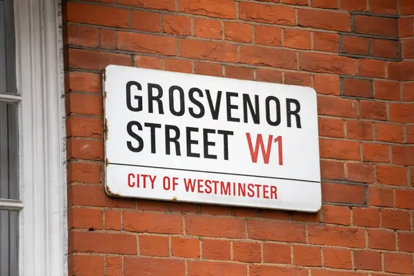 Londra 'nın Westminster şehrindeki Grosvenor Sokağı için bir tabela. Tabela tuğla bir duvara asılmış..