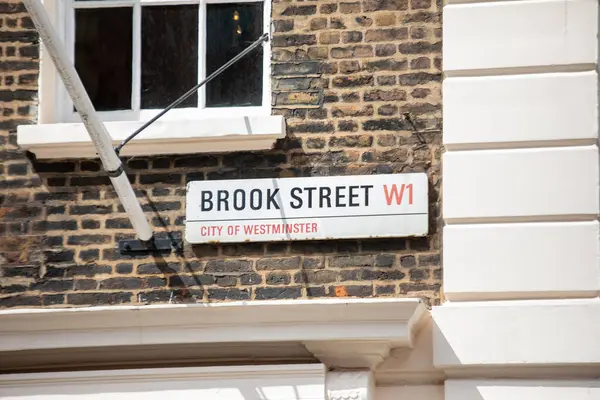 Westminster, Londra 'da Brook Caddesi' nin sokak tabelası. Görüntü, tuğla bina cephesindeki tabelayı gösteriyor..