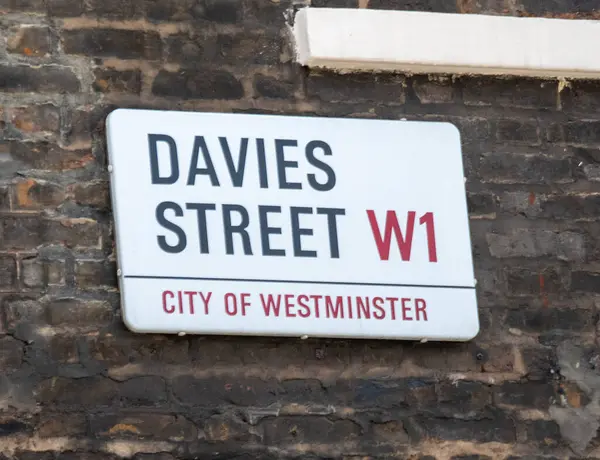 Westminster, Londra 'daki Davies Sokağı tabelasının yakın çekimi. Tabela tuğla bir duvara asılmış..