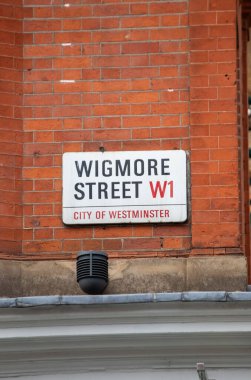 Westminster, Londra 'daki Wigmore Sokağı' nın sokak tabelası. Kırmızı tuğla arkaplan ve alan ayrıntıları gösterilir.