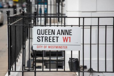 Westminster, Londra 'daki Queen Anne Caddesi için sokak tabelası. Tabela şehrin kaldırımındaki metal bir çite asılmış..