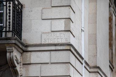 Londra 'da klasik bir taş bina üzerindeki Harley Sokağı tabelasına yakın çekim. Cadde, tıbbi ofisleri ve tarihi mimarisi ile ünlüdür..