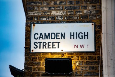 Londra 'daki Camden High Street için sokak tabelası, tuğla bir duvara asılmış. İşaret sokak lambasıyla aydınlatılıyor..