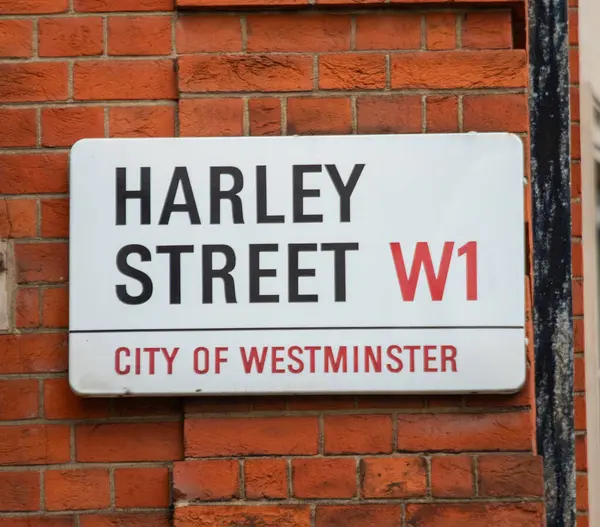 Londra 'nın Westminster şehrindeki Harley Sokağı tabelasına yakın çekim. Tıbbi uygulamalarıyla tanınan ikonik konum.