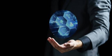 Takım elbiseli işadamı simgelerle dijital teknoloji arayüzü gösteriyor.