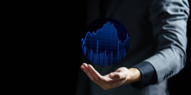 Elinde stok grafiği ve grafiği olan dijital tablet tutan iş adamı